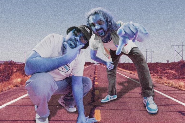 Australian band Bootleg Rascal duo tinted blue posing on a desert highway background, wearing sunglasses, sneakers, and casual streetwear.
